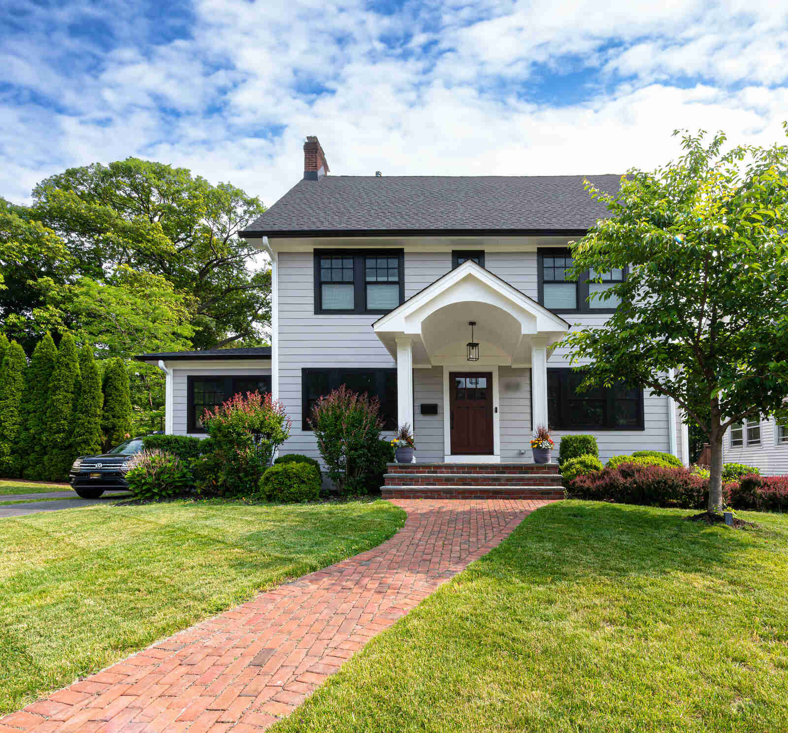 Exterior view of renovated home with brick sidewalk