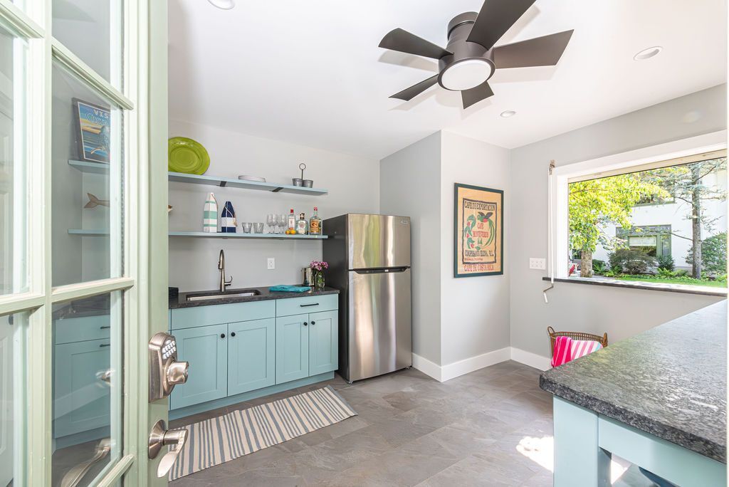 Bright kitchenette with modern fan and large pass-through window to pool area in East Hanover, NJ by G&L and Sons Renovations