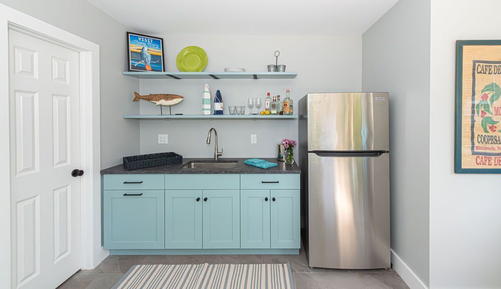 Coastal-inspired kitchenette with aqua cabinetry and stainless fridge in Glen Ridge, NJ by G&L and Sons Renovations