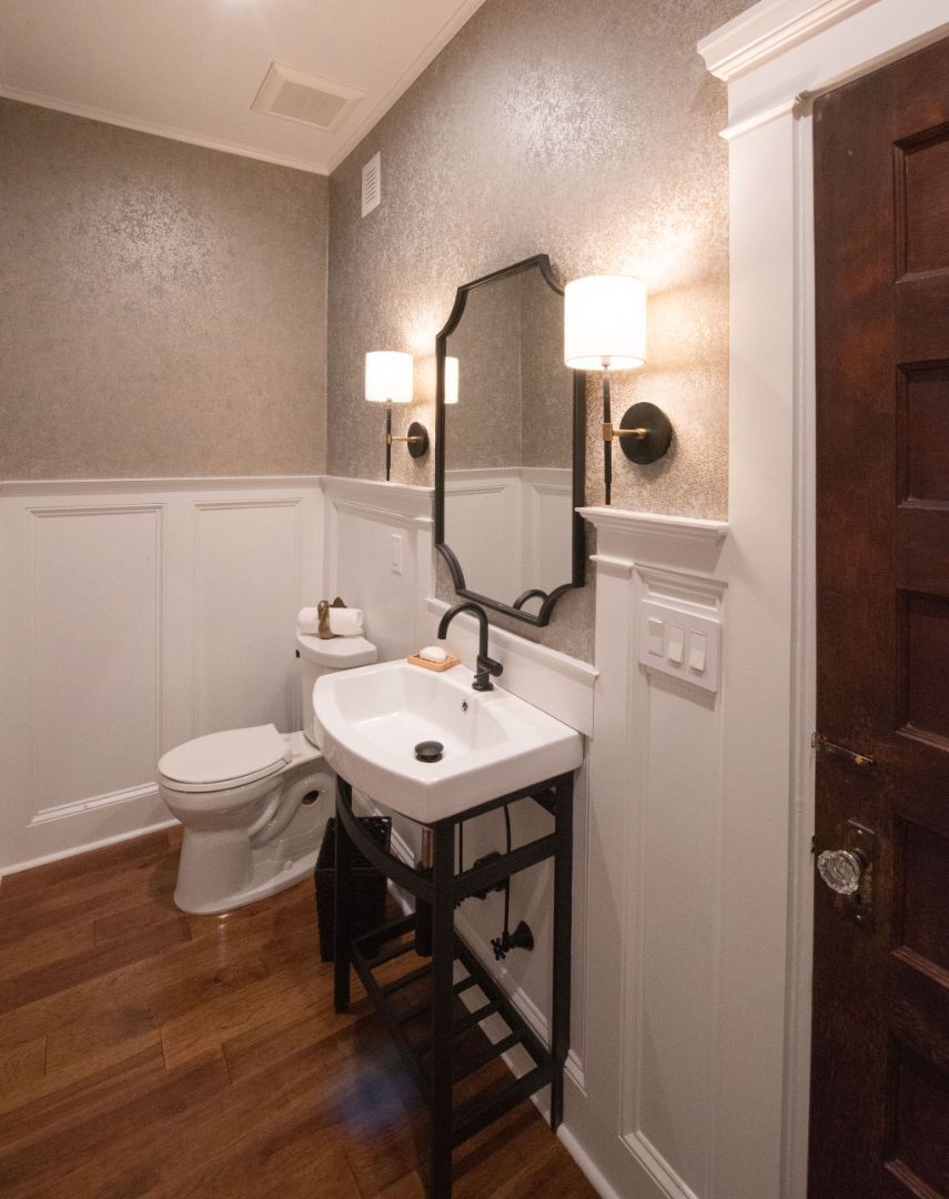 Elegant powder room with wall-mounted sink and dark wood flooring by G&L and Sons Renovations in Chatham Boro, NJ