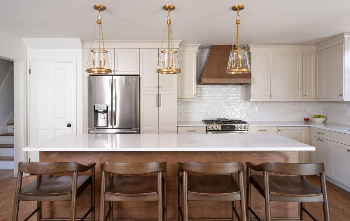 Full view of bright white kitchen with wood accents and pendant lights in Livingston, NJ by G&L and Sons Renovations