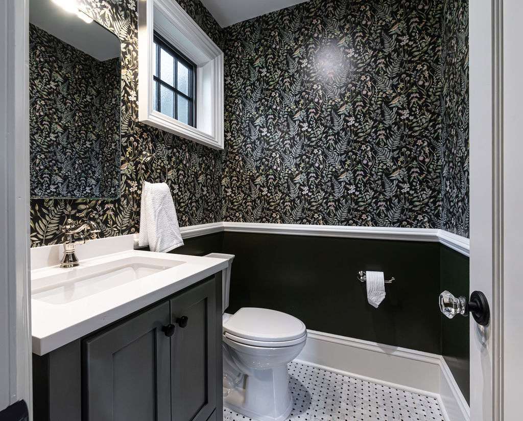 Half bath design with dark cabinetry and printed walls in Woodland Park, NJ by G&L and Sons Renovations