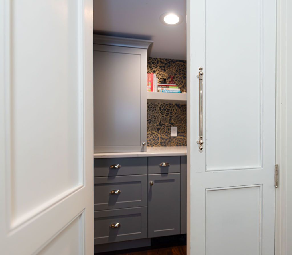 Hidden walk-in pantry with floral wallpaper and custom shelving in a Cedar Grove, NJ home by G&L and Sons Renovations