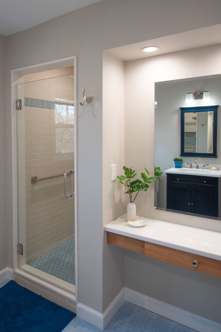 Light-filled bathroom vanity and walk-in shower with blue accents in West Caldwell, NJ by G&L and Sons Renovations