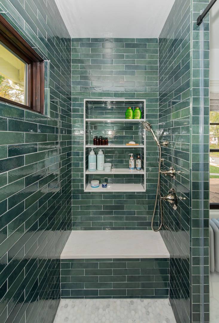 Stylish bathroom renovation featuring modern tile and seating ledge in Chatham Township, NJ by G&L and Sons Renovations