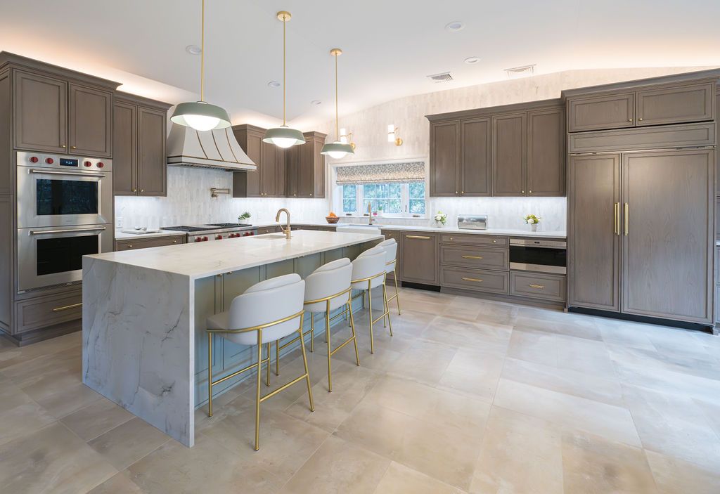 Stylish kitchen renovation with gold pendant lights and waterfall island in Clifton, NJ by G&L and Sons Renovations
