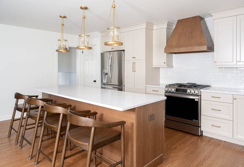 White kitchen with wood island and brass lighting in Chatham Township, NJ by G&L and Sons Renovations