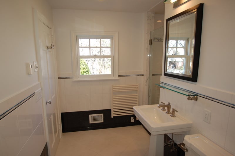 Custom master bathroom vanity area with pedestal sink and framed mirror by G&L and Sons Renovations in Fairfield, NJ