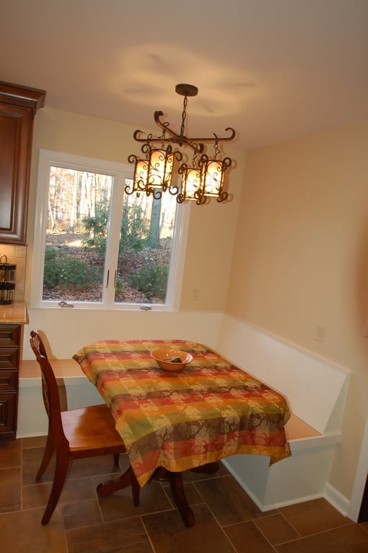Eat-in kitchen with colorful table setting and built-in bench by G&L and Sons Renovations in Caldwell, NJ