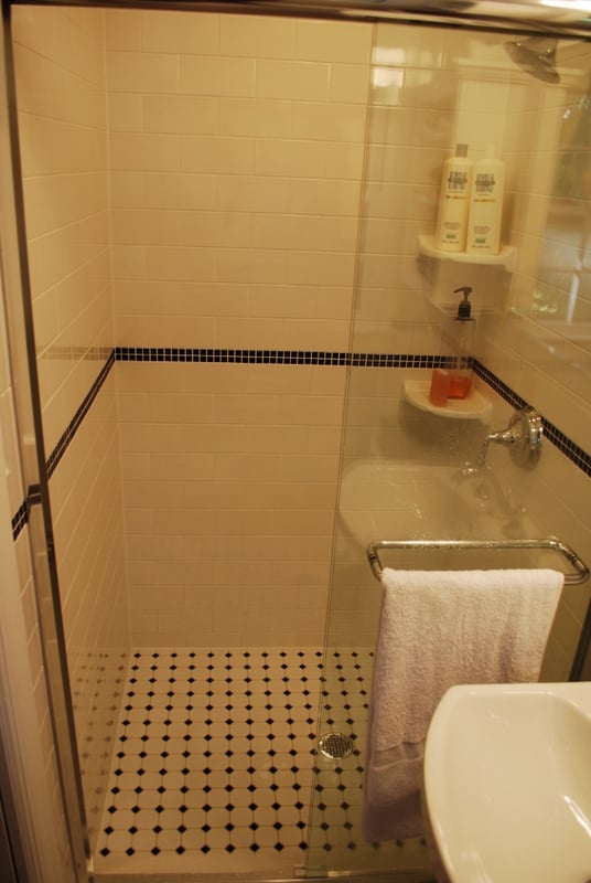 Large walk-in shower with white subway tile and black accent trim by G&L and Sons Renovations in Short Hills, NJ
