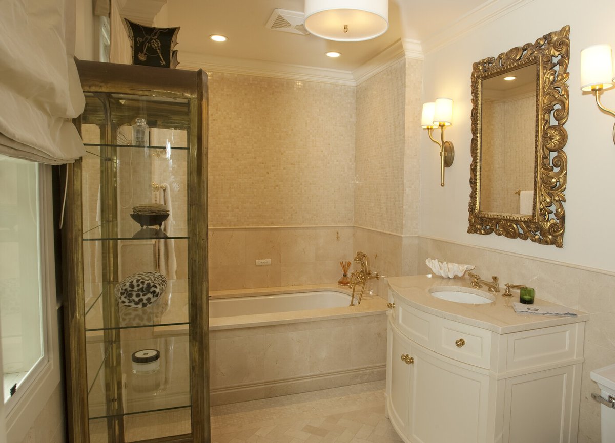 Luxurious beige-toned master bathroom with ornate mirror and soaking tub by G&L and Sons Renovations in Livingston, NJ