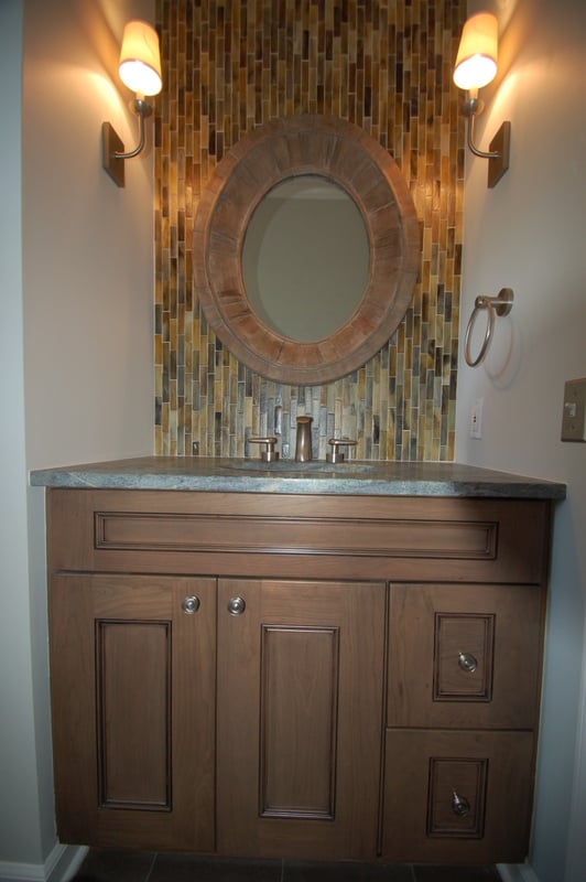 Rustic-inspired vanity with round mirror and glass tile wall by G&L and Sons Renovations, Caldwell, NJ