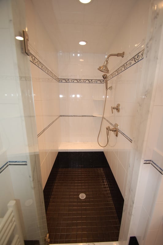 Up-close look at tiled walk-in shower with bench and recessed lighting by G&L and Sons Renovations in Florham Park, NJ