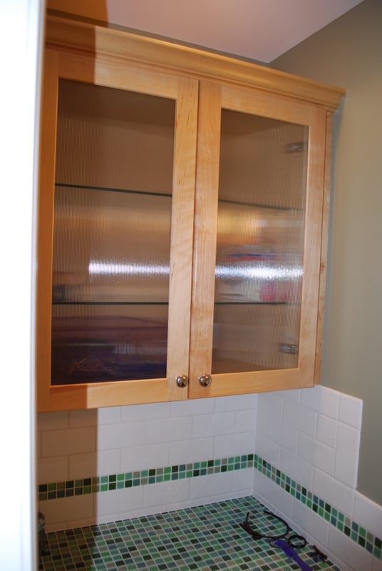 Upper bathroom cabinetry with fluted glass doors and wood trim by G&L and Sons Renovations in Glen Ridge, NJ