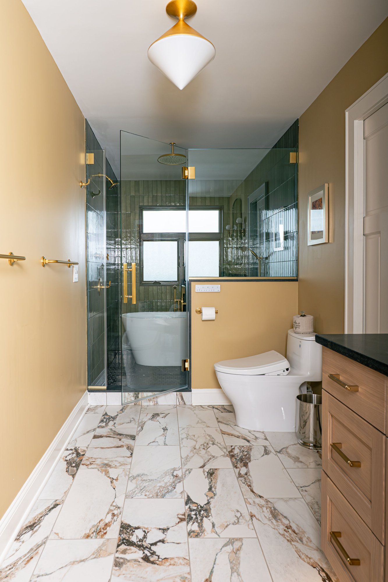 Image of a custom bathroom in Bergen County, New Jersey, with a large, green tiled shower, a standalone garden tub, white oak cabinetry, and a Toto toilet with bidet seat. Image of a custom bathroom in Bergen County, New Jersey, with a large, green tiled shower, a standalone garden tub, white oak cabinetry, and a Toto toilet with bidet seat.