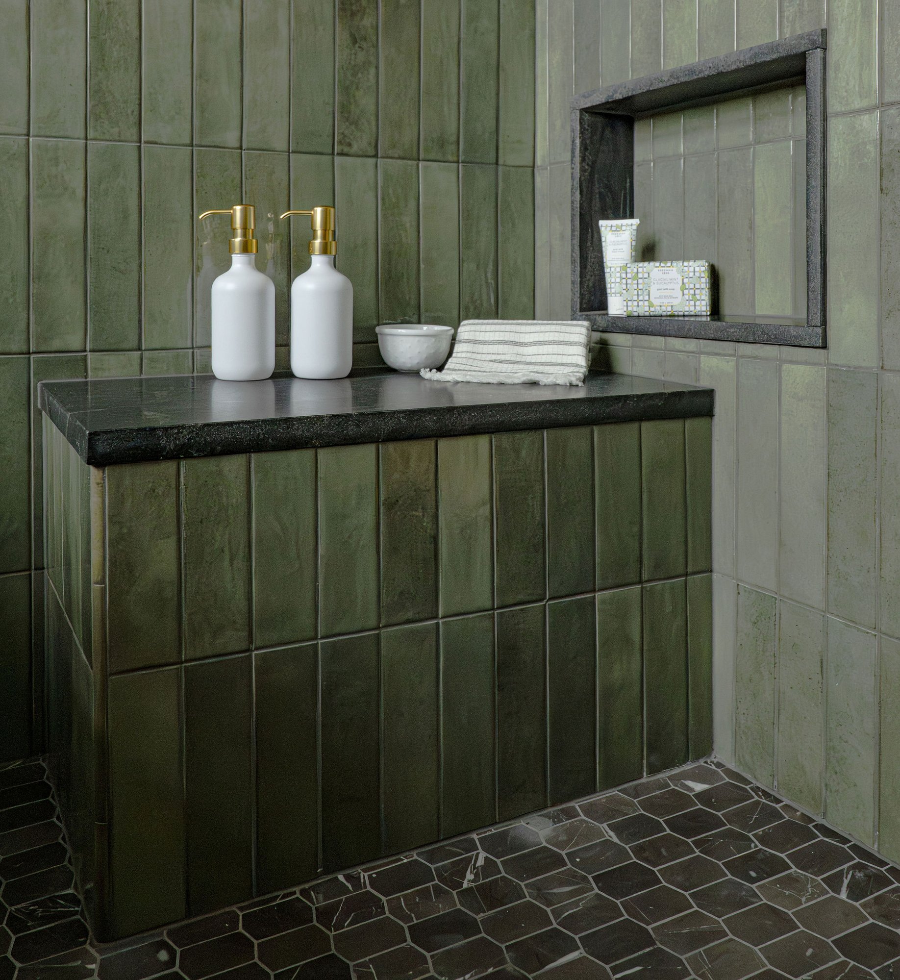 Image of Image of a custom bathroom in Bergen County, New Jersey, with a large, green tiled shower, brass fixtures, and a black, granite countertop with a decorative backsplash. Image of Image of a custom bathroom in Bergen County, New Jersey, with a large, green tiled shower, brass fixtures, and a black, granite countertop with a decorative backsplash.
