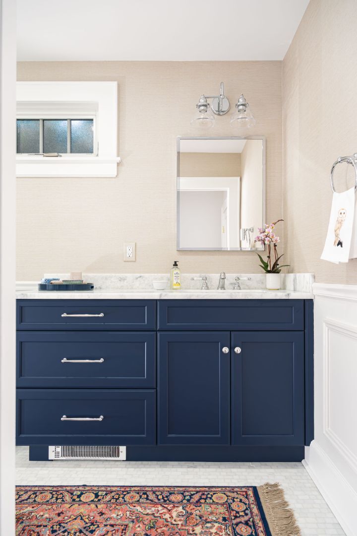 navy blue bathroom vanity with marble countertop in a house remodeled by G&amp;L and Sons Renovations in Montclair, NJ