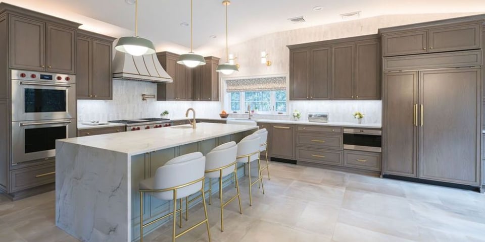 Stylish kitchen renovation with gold pendant lights and waterfall island in Clifton, NJ by G&L and Sons Renovations