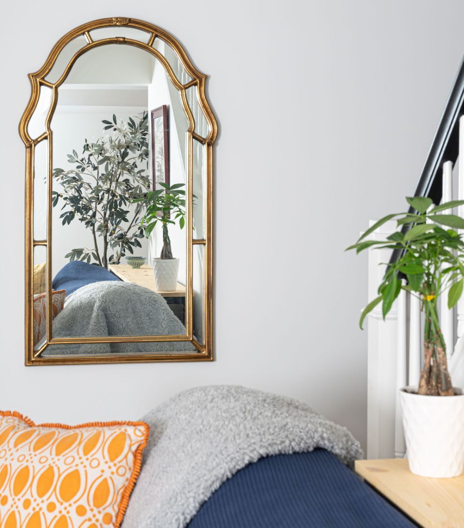 Modern sitting area with neutral loveseat, green and yellow accents, and an eclectic art wall. | G&L and Sons Renovations