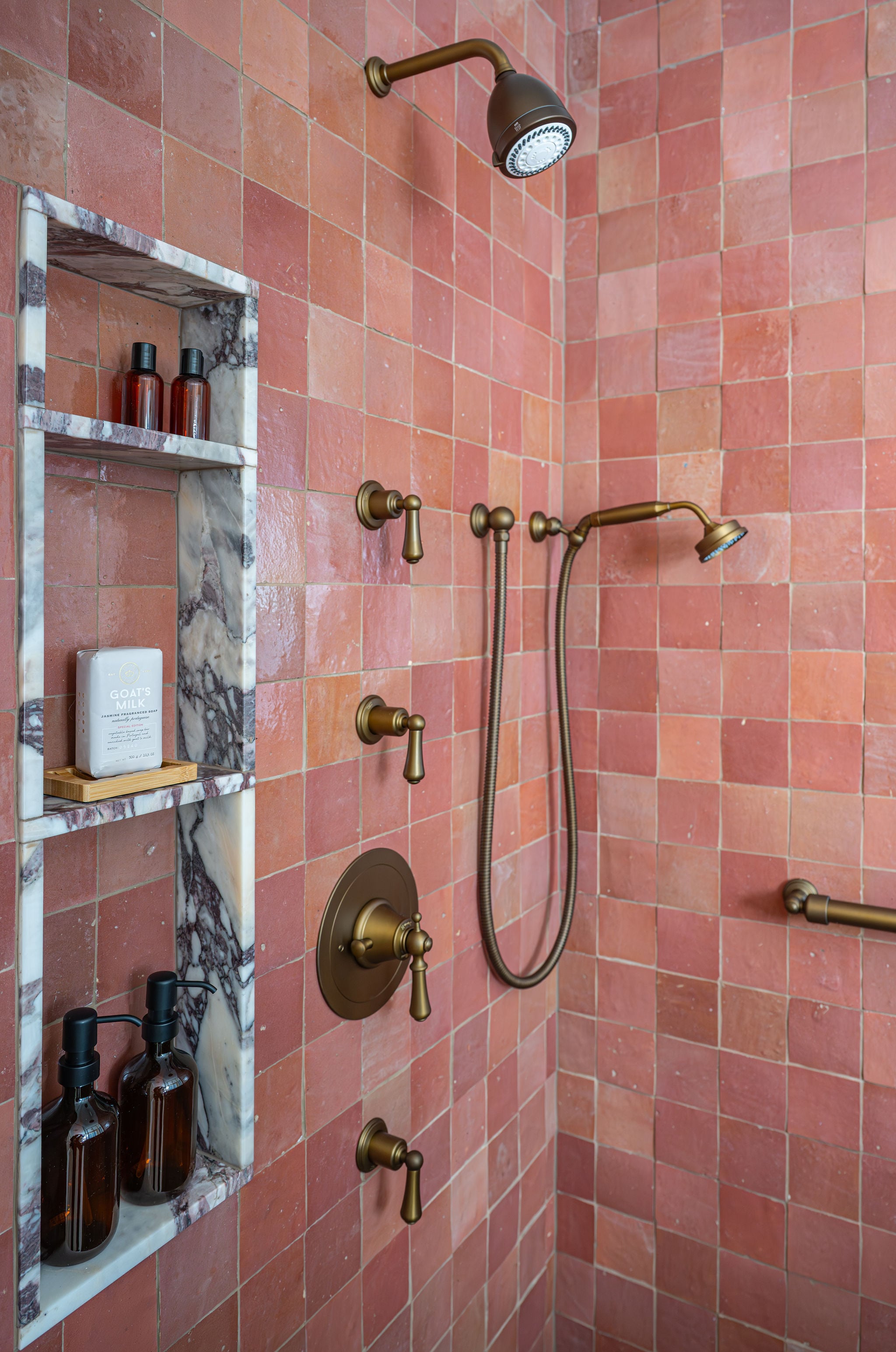 Image of a custom bathroom in Bergen County, New Jersey, with a rain shower and handheld shower with pastel handmade Moroccan wall tiles and brass fixtures.