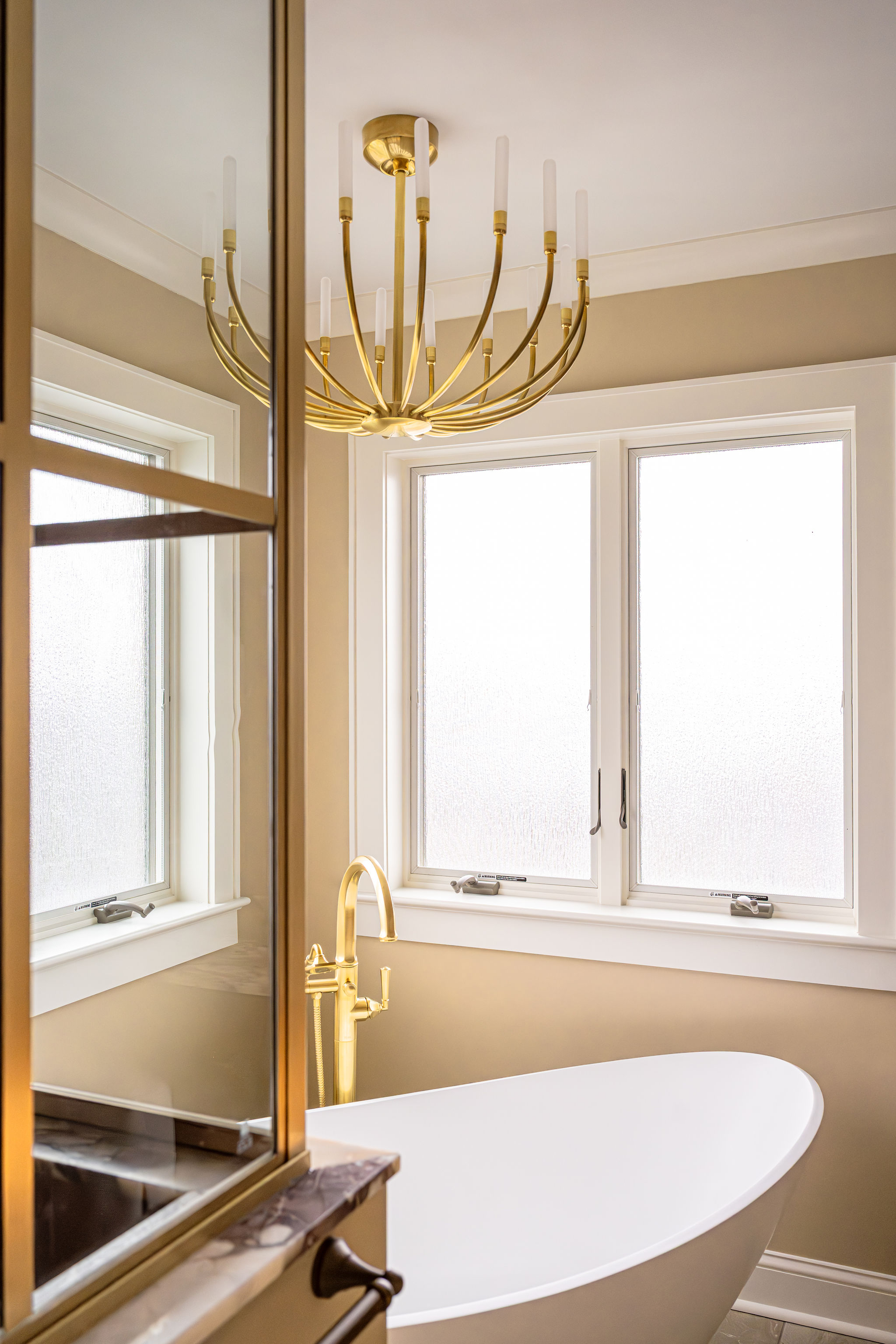 Image of a custom bathroom in Bergen County, New Jersey, with a glass walk-in shower, rain shower head, and a standalone garden tub..
